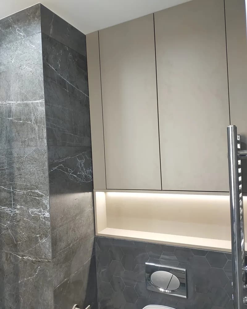Handleless fitted bathroom storage with an illuminated open shelf
