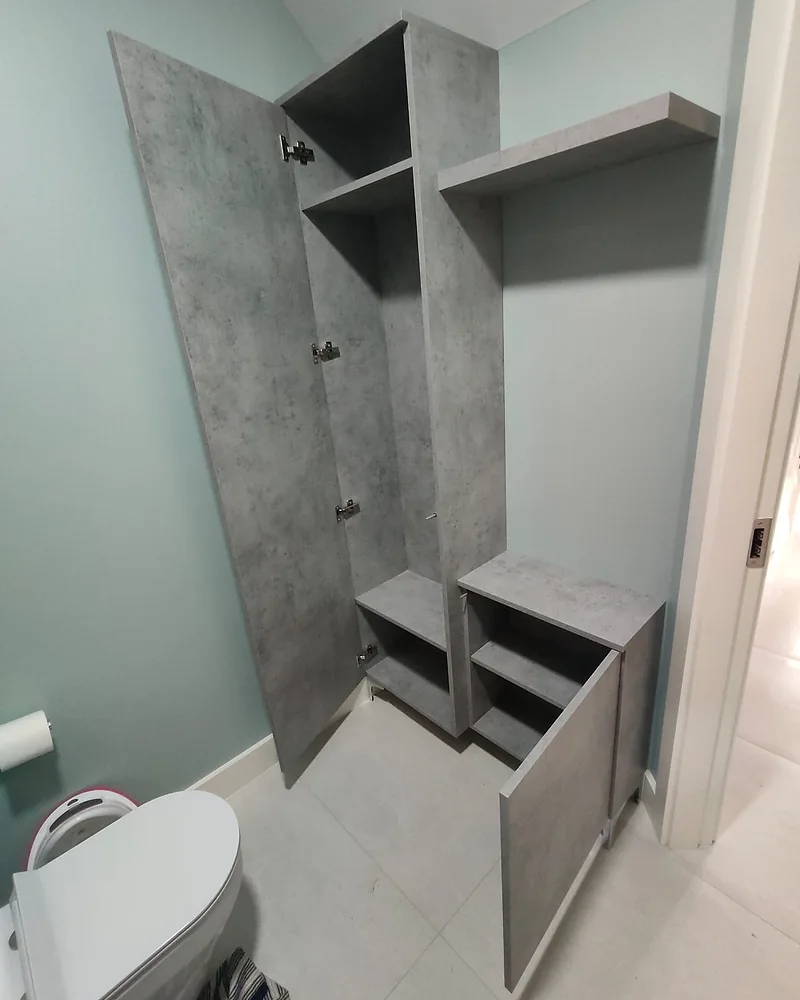 Open concrete-effect bathroom cabinets with fitted shelves and concealed storage