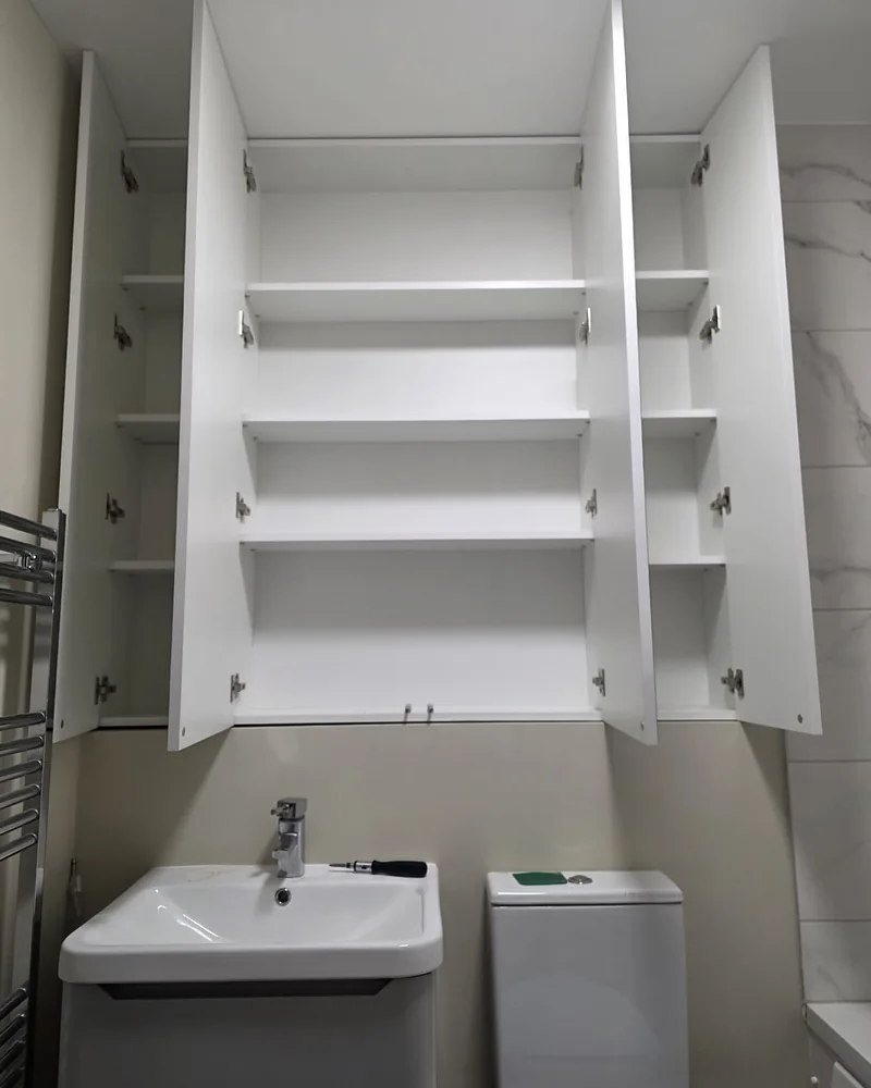 Open mirrored bathroom cabinets showing concealed internal shelving