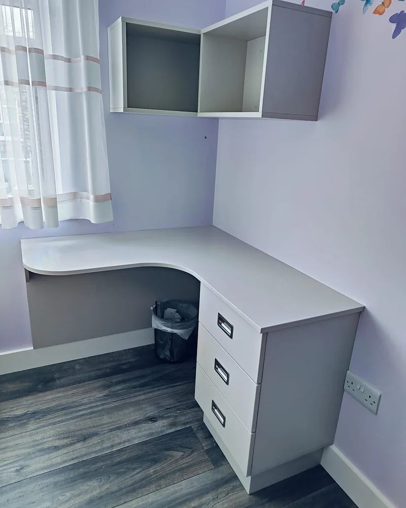 Custom corner desk with fitted drawers and wall-mounted storage