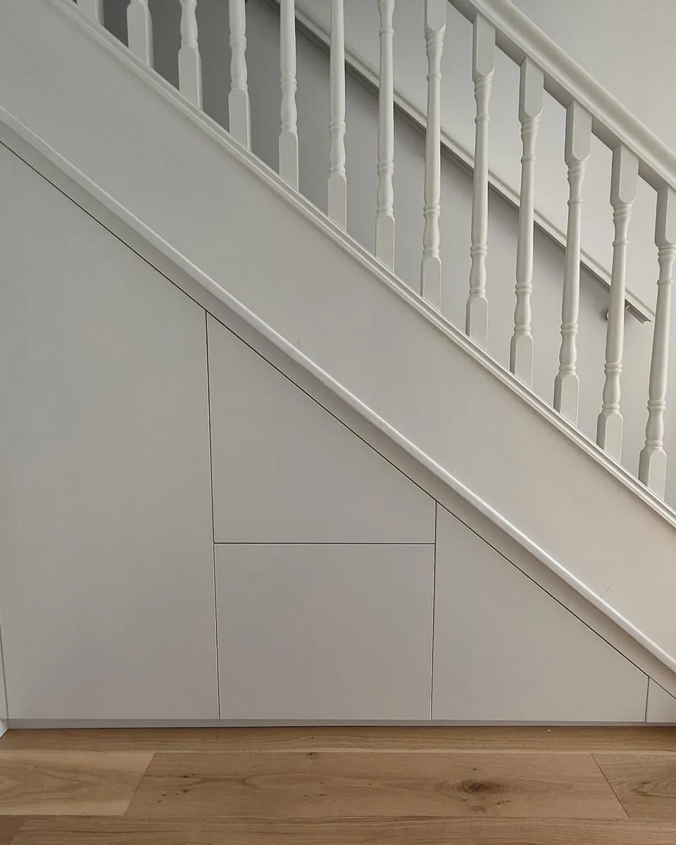 Bespoke white under-stairs storage with flush fitted doors