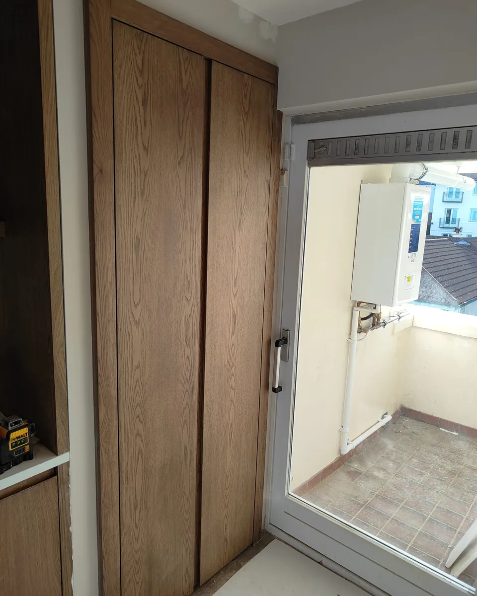 Floor-to-ceiling utility storage with timber-effect fitted doors