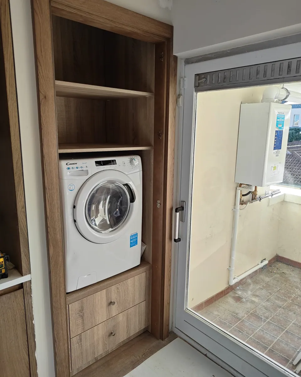 Open utility storage revealing an integrated washing machine and shelving