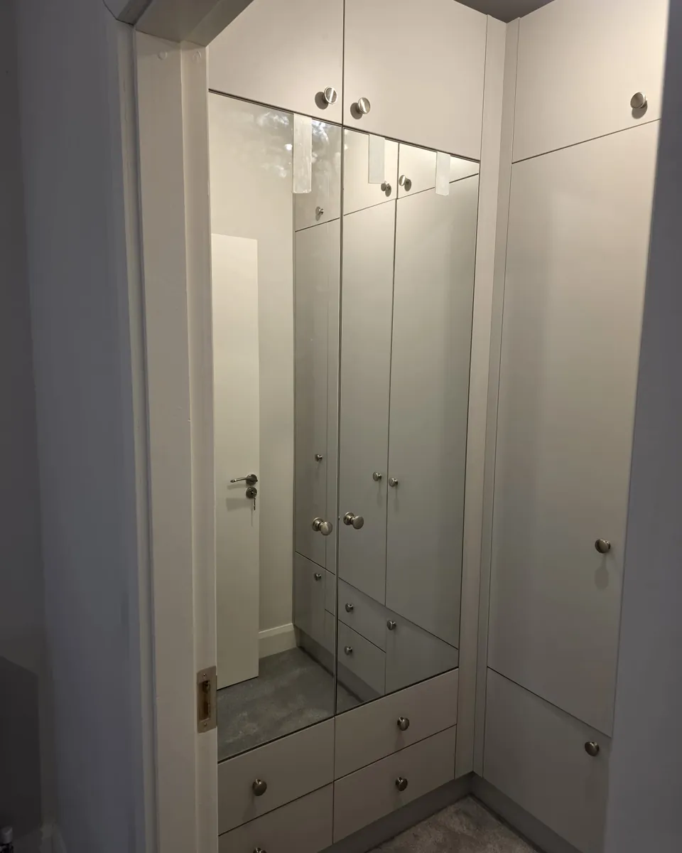 Bespoke hallway cabinetry with mirrored doors and integrated drawers