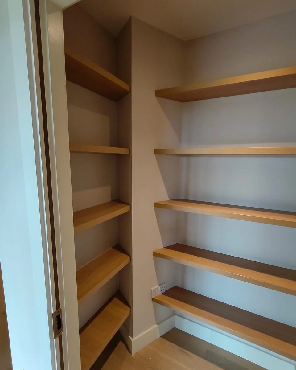 Bespoke pantry shelving with solid timber shelves in a compact room
