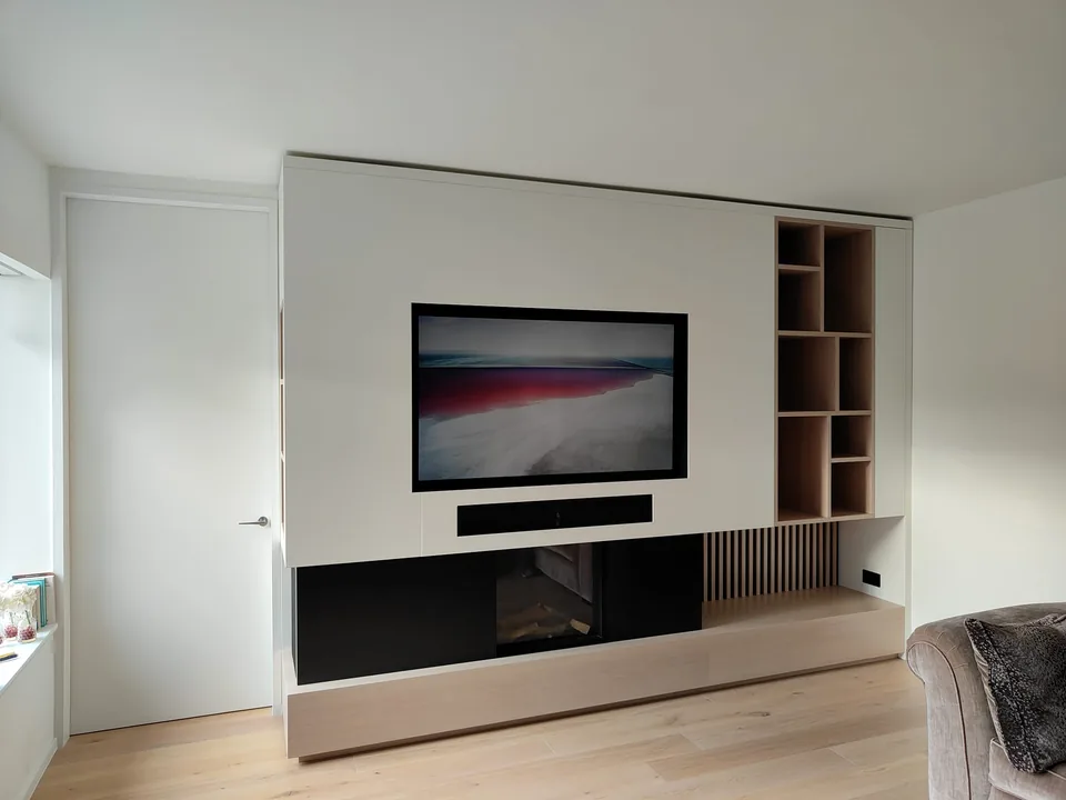 Custom white and black TV media wall with integrated fireplace and open shelving
