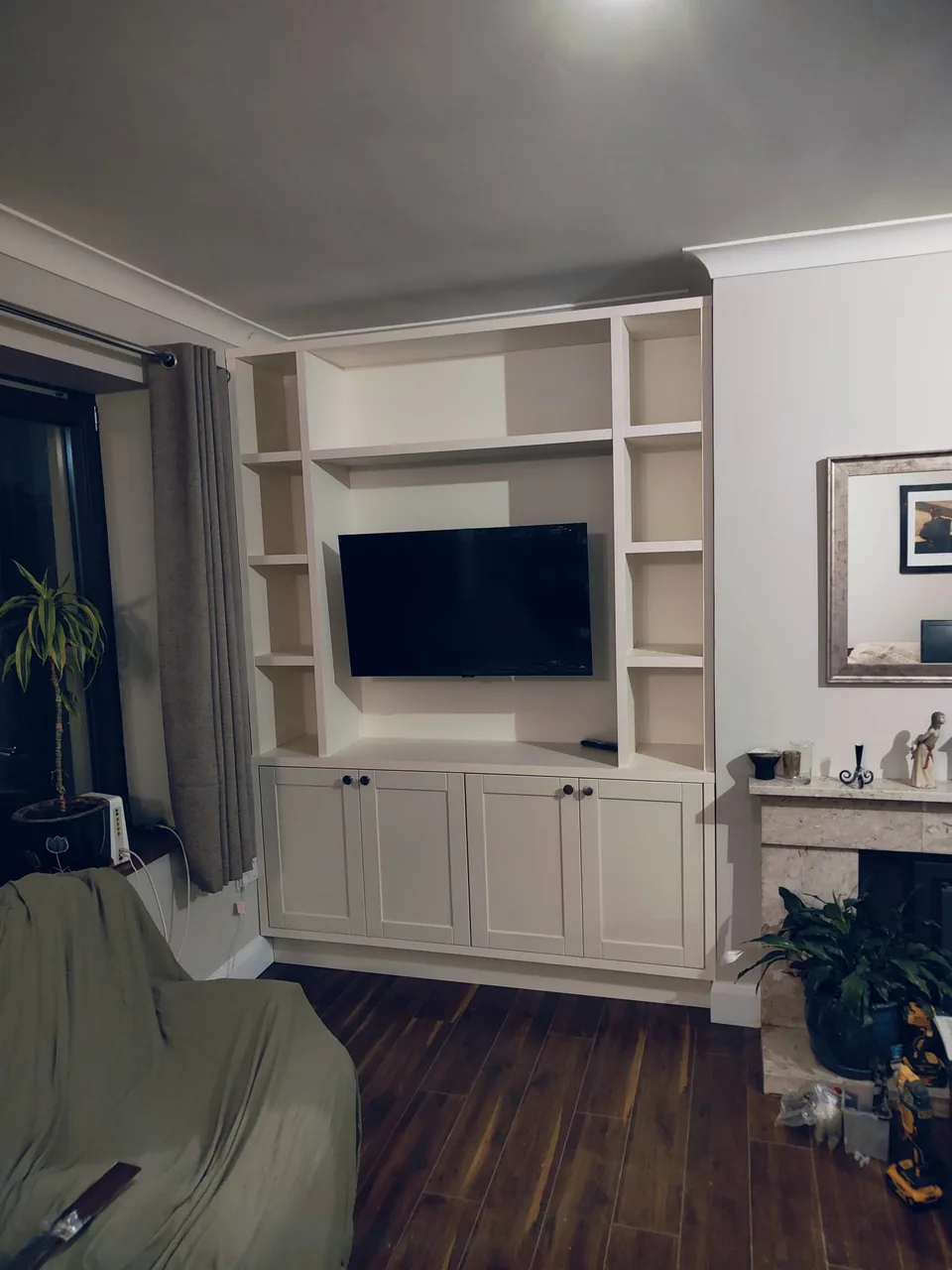 Traditional white built-in TV cabinet with shelving and lower storage