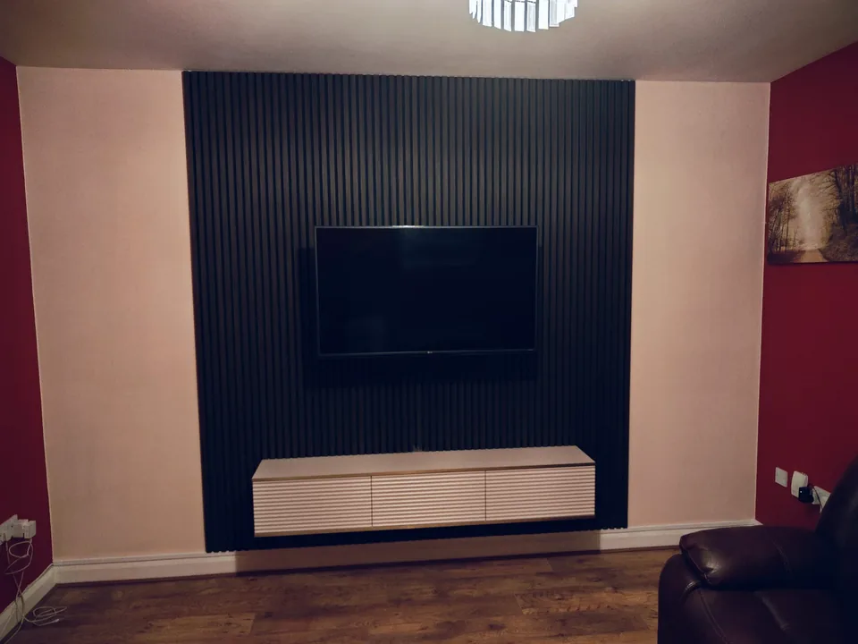 Completed black slat TV feature wall with a floating white cabinet