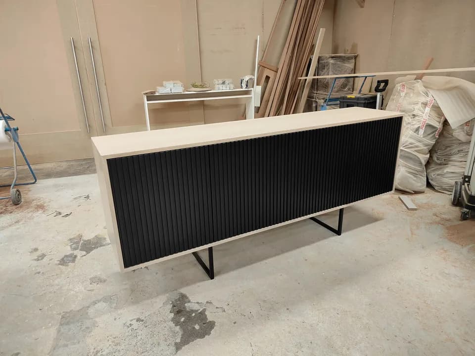 Custom black fluted media cabinet photographed during workshop fabrication